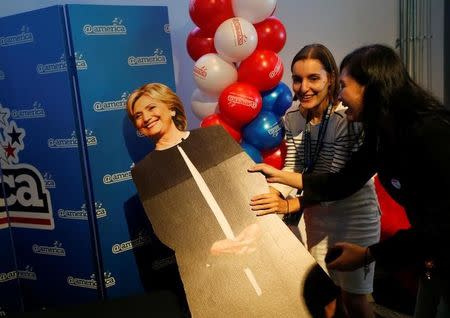 Women hold a cardboard cut-out of the Democratic U.S. presidential candidate Hillary Clinton during an elections event at the U.S. embassy's cultural center in Jakarta, Indonesia November 9, 2016. REUTERS/Beawiharta