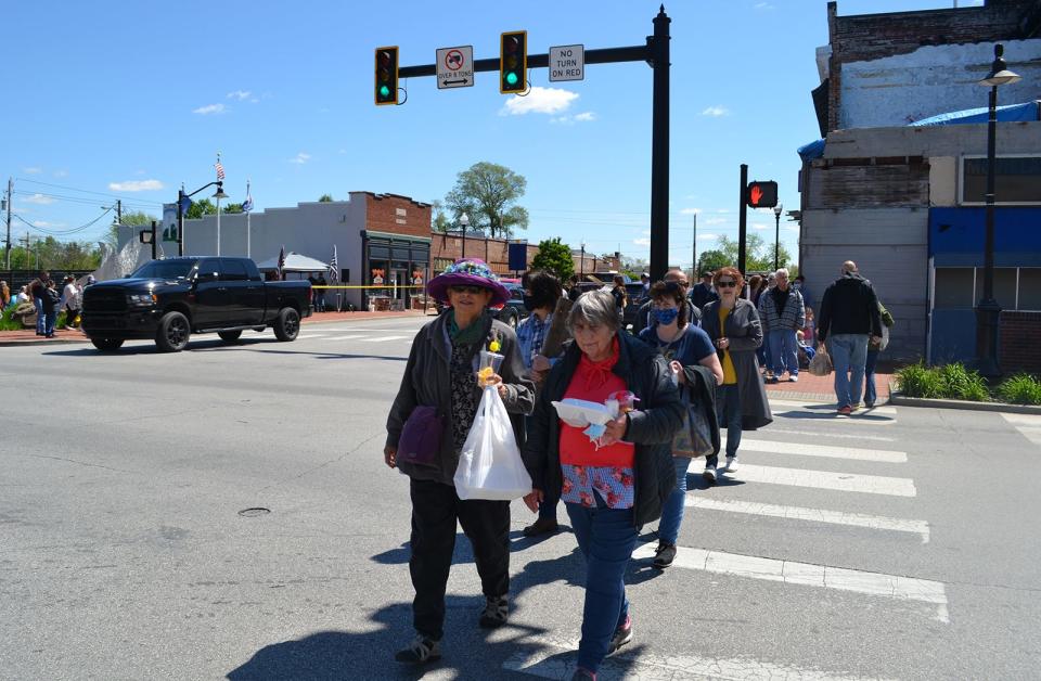 A line of people cross Indiana Street in Mooresville during a Downtown Mooresville Street Fair in 2021.