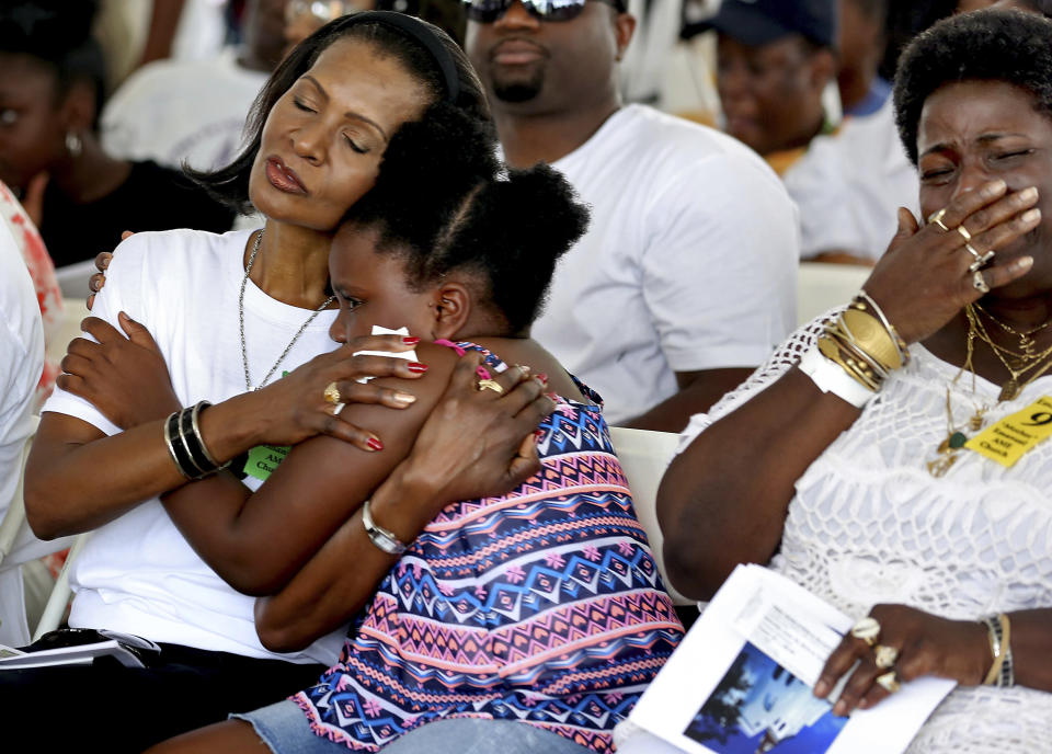 FILE - In this June 18, 2016, file photo, Verda Graham, left, sister-in-law of Cynthia Graham-Hurd, comforts her granddaughter, Laila Campbell, during a tree dedication to honor the lives lost and the survivors of the Mother Emanuel AME Church shootings in Charleston, S.C. (Grace Beahm/The Post And Courier via AP, File)