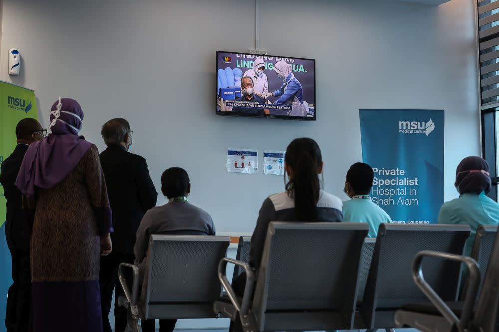 Staff at the MSU Medical Centre watch a live broadcast of Prime Minister Tan Sri Muhyiddin Yassin receiving his Covid-19 jab in Shah Alam February 24, 2021. ― Picture by Yusof Mat Isa