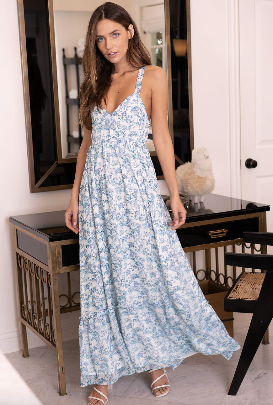 brunette model in blue and white floral My Love Story White Floral Print Tie-Back Maxi Dress (Photo via Lulus)