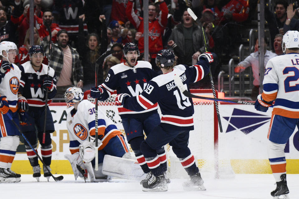 Washington Capitals center Craig Smith (16) celebrates after his goal against New York Islanders goaltender Ilya Sorokin (30) with center Nicklas Backstrom (19) during the first period of an NHL hockey game Monday, April 10, 2023, in Washington. (AP Photo/Nick Wass)