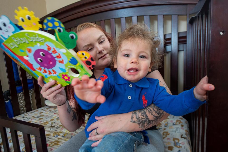 Patricia, left, tries to read to her son, Noah, 15 months, as he is more interested in having his picture taken, at their home in Bristol Township, on Friday, Nov. 18, 2022.