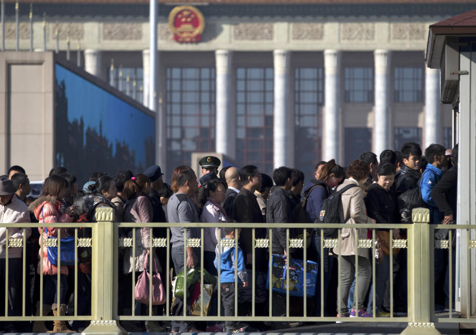 A Chinese paramilitary policeman, center back, stands guard as people line up for security check before entering Tiananmen Square in Beijing Thursday, Nov. 1, 2012. Beijing is tightening security as its all-important Communist Party congress approaches, and some of the measures seem bizarre. Most of the security measures were implemented in time for Thursday's opening of a meeting of the Central Committee. (AP Photo/Andy Wong)