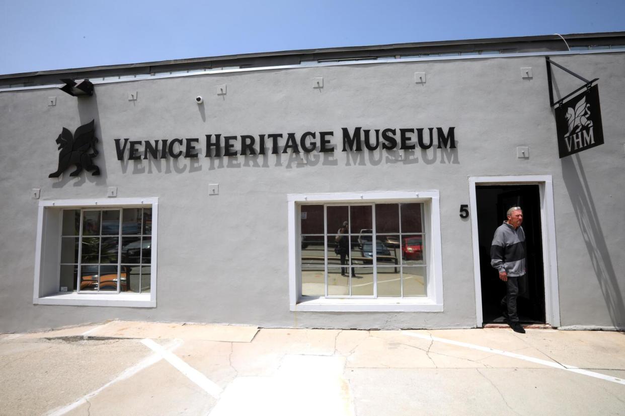 A man exits a building signed "Venice Heritage Museum."