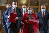 New Zealand Finance Minister Grant Robertson, front left, is on his way to present his budget to Parliament with ministers, from left, David Parker, obscured, Andrew Little, Megan Woods, and Peeni Henare, right, in Wellington, New Zealand, Thursday, May 19, 2022. New Zealand's government said Thursday it will hand out an extra few hundred dollars to about half of all adults to help them navigate what it describes as "the peak of the global inflation storm." (Mark Mitchell/NZ Herald via AP)