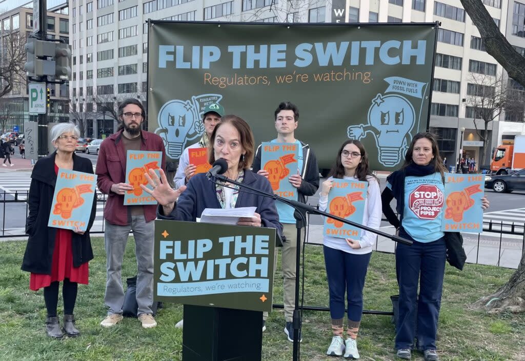 A coalition of climate justice groups organized a rally Monday outside the Washington, D.C., hotel where the National Association of Regulatory Utility Commissioners is holding its winter policy meeting. The speakers, including  Christine Pendzich, center, of Montgomery County, Md., took aim in part at energy company and utility sponsorship of the event. (Photo by Robert Zullo/States Newsroom) 