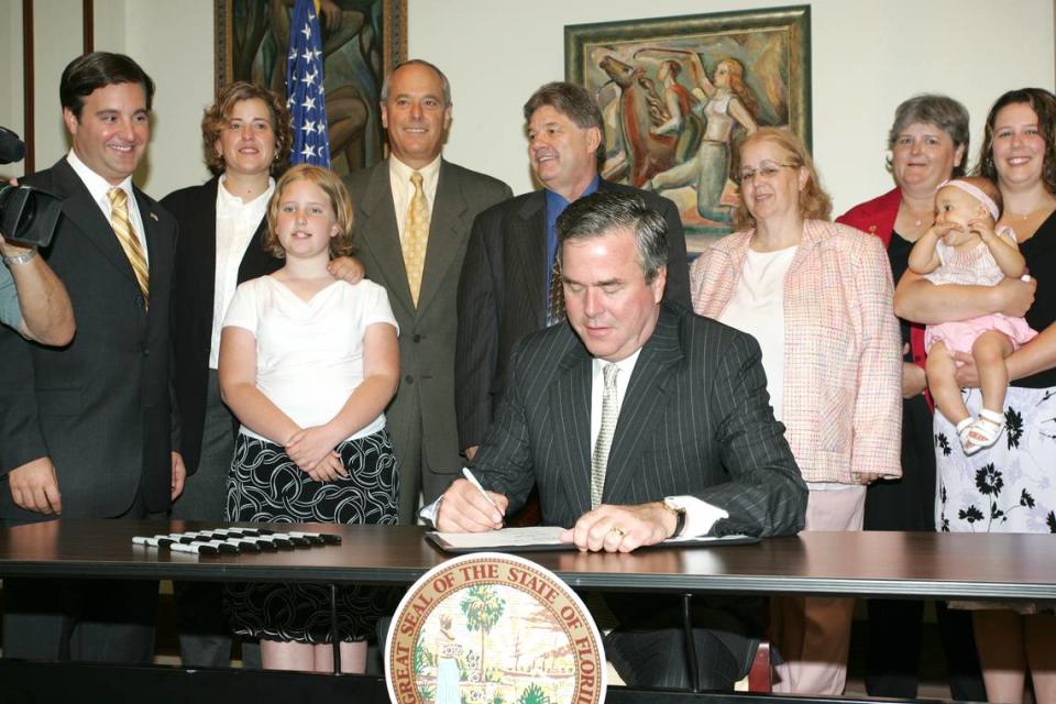 Florida Gov. Jeb Bush signs the Chad Meredith Act into law at the University of Miami in Coral Gables, Florida, on Tuesday, June 7, 2005.