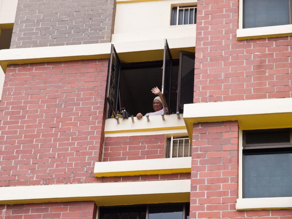 A resident waving to PAP's Desmond Choo as the PAP convoy arrived at her block. (Yahoo! photo/Alvin Ho)