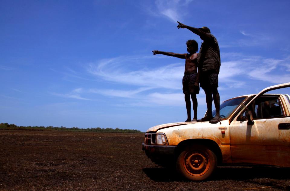 Australian Aboriginal hunters Bruce and Robert Gaykamangu look for potential prey at a billabong near the outstation of Ngangalala in East Arnhem Land. (REUTERS/David Gray)