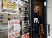 Lamar Johnson stands for a portrait at St. Sabina Church in Chicago, Friday, Nov. 9, 2018. Johnson, 28, is a counselor for the church program, B.R.A.V.E. Youth Leaders. He teaches kids as young as 6 how to speak out against gun violence and be social justice activists. The church also offers rewards for community members who provide tips that help police solve murders. The window shows a poster seeking help in finding the gunman who fatally shot a 21-year-old woman in the community in July. (AP Photo/Nam Y. Huh)