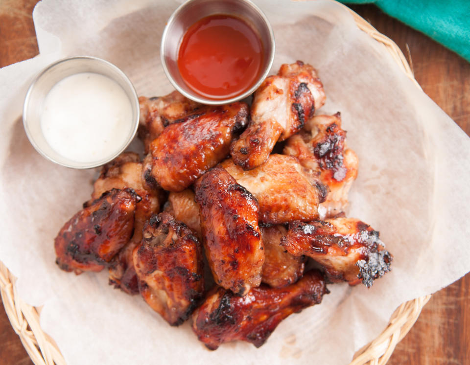 A plate of chicken wings with hot sauce.