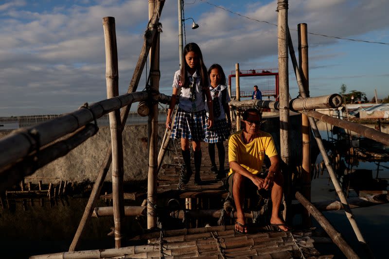 The Wider Image: Rising seas threaten early end for sinking village in Philippines