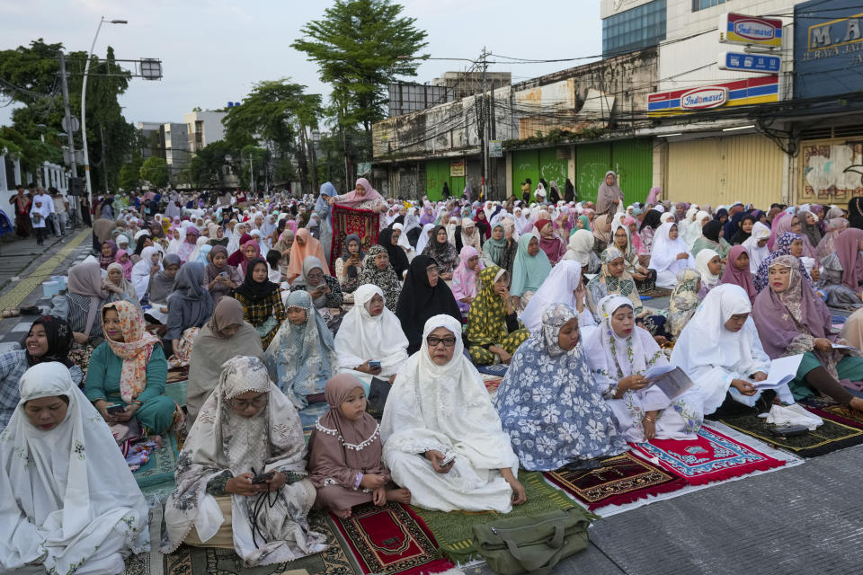 Muslims attend a morning prayer marking the Eid al-Adha holiday on a street in Jakarta, Indonesia, Thursday, June 29, 2023. Muslims around the world will celebrate Eid al-Adha, or the Feast of the Sacrifice, slaughtering sheep, goats, cows and camels to commemorate Prophet Abraham's readiness to sacrifice his son Ismail on God's command. (AP Photo/Tatan Syuflana)