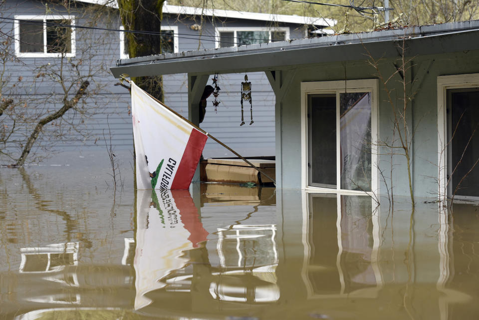 A California state flag hangs from the front of a home submerged in the flood waters of the Russian River in Forestville, Calif., on Feb. 27, 2019. (Photo: Michael Short/AP)