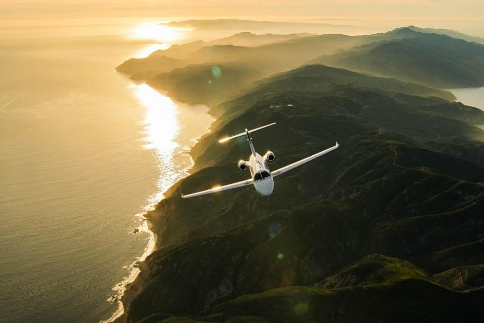 The M2 flying over green mountains.