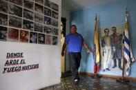 A man walks past a mural depicting Latin American political and military leader Simon Bolivar and Uruguayan hero Jose Artigas at the Uruguayan Center in Caracas December 16, 2014. REUTERS/Carlos Garcia Rawlins