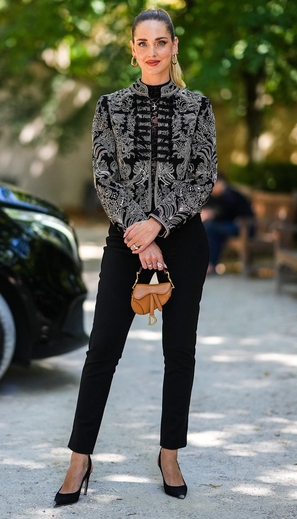 <p>Chiara Ferragni pairs her intricately detailed Dior jacket with a tiny Dior saddle bag for the brand's Paris show.</p>