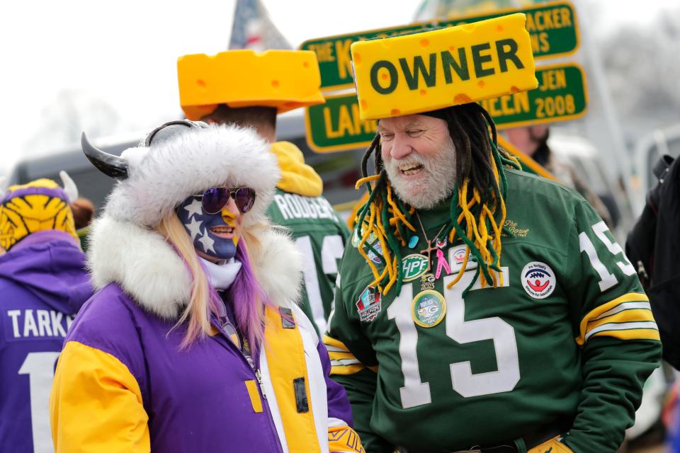 Jan 1, 2023; Green Bay, Wisconsin, USA; Minnesota Vikings fan Tali Roberts, left, of Nashville shares a laugh Green Bay Packers fan Steve Tate of DeForest, Wisconsin, prior to the start of their football game at Lambeau Field. Mandatory Credit: Dan Powers-USA TODAY Sports