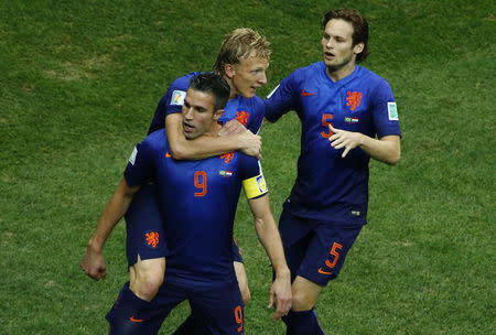 Robin van Persie of the Netherlands celebrates his goal against Brazil with his teammates Dirk Kuyt (C) and Daley Blind (R). REUTERS/Ruben Sprich