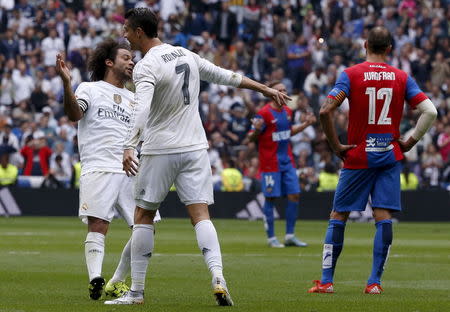 Real Madrid's striker Cristiano Ronaldo celebrates a goal with his teammate Marcelo (L) during their Spanish First Division soccer match against Levante at Santiago Bernabeu stadium in Madrid, October 17, 2015. REUTERS/Juan Medina -