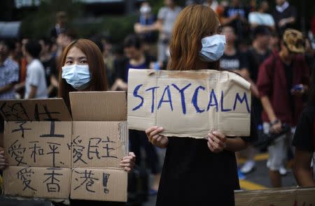 Protesters gather around the Golden Baihinia Square during an official flag raising ceremony to commemorate the Chinese National Day in Hong Kong, October 1, 2014. REUTERS/Carlos Barria