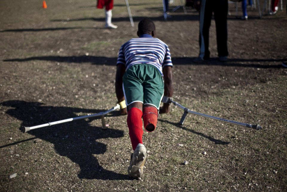 In this picture taken on Feb. 16, 2012, a resident of La Piste camp, Jean Lacroix, 27, whose right leg was amputated due to an injury suffered in a motorcycle accident, trains with his football team in Port-au-Prince, Haiti. While more than a million people displaced by the 2010 quake ended up in post-apocalyptic-like tent cities, some of the homeless people with disabilities landed in the near-model community of La Piste, a settlement of plywood shelters along tidy gravel lanes. However, the rare respite for the estimated 500-plus people living at the camp is coming to an end as the government moves to reclaim the land. (AP Photo/Ramon Espinosa)