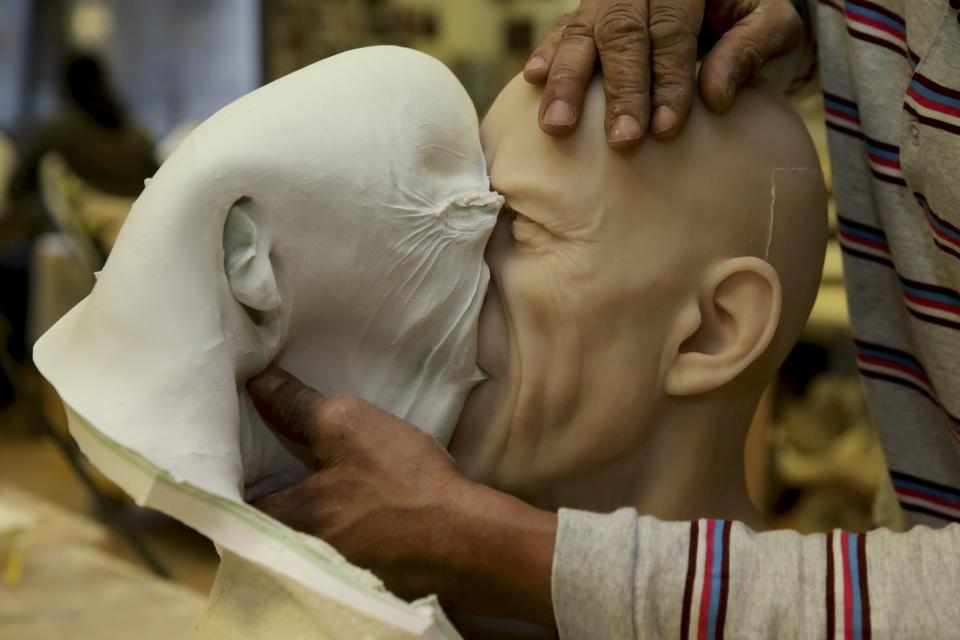 Paris' Grevin Wax Museum technician Carlos Brito opens the mould of the head of Rolling Stones lead singer Mick Jagger at their workshop in Paris