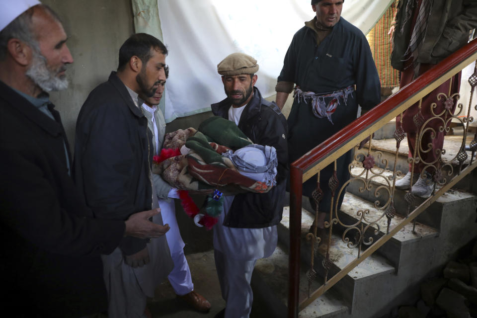 Relatives carry the dead body of a boy who was killed by a mortar shell attack in Kabul, Afghanistan, Saturday, Nov. 21, 2020. Mortar shells slammed into different parts of the Afghan capital on Saturday. (AP Photo/Rahmat Gul)