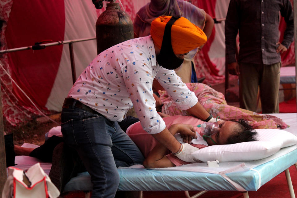 A man having difficulty breathing is attended to by a volunteer as he receives free oxygen outside a Gurudwara (Sikh temple) in Ghaziabad, on the outskirts of New Delhi, India, May 6, 2021. / Credit: Mayank Makhija/NurPhoto/Getty