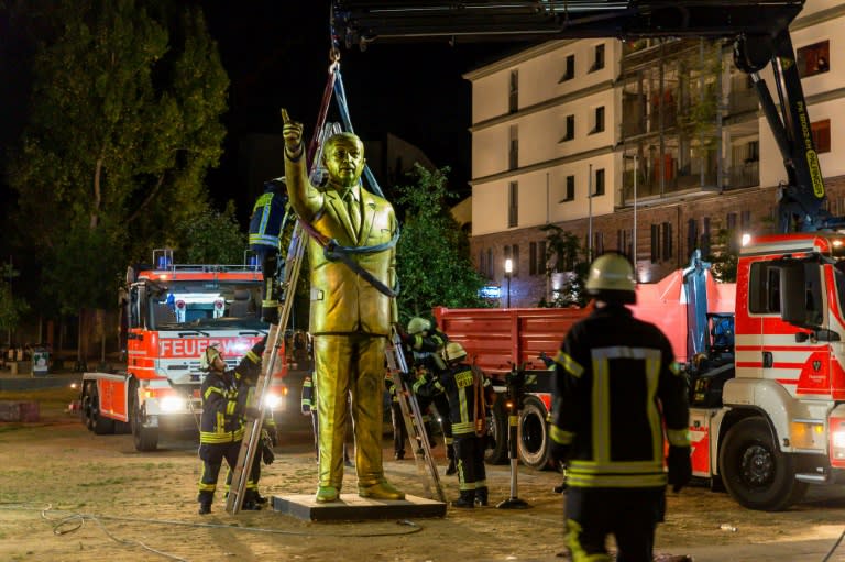 Firefighters use a crane to remove a four-metre golden statue of Turkish President Recep Tayyip Erdogan from a town square in the German city of Wiesbaden