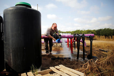 A farmer tends to a water faucet in a field in Kibbutz Nahal Oz, near the Gaza Strip border, Israel April 8, 2018. REUTERS/Amir Cohen