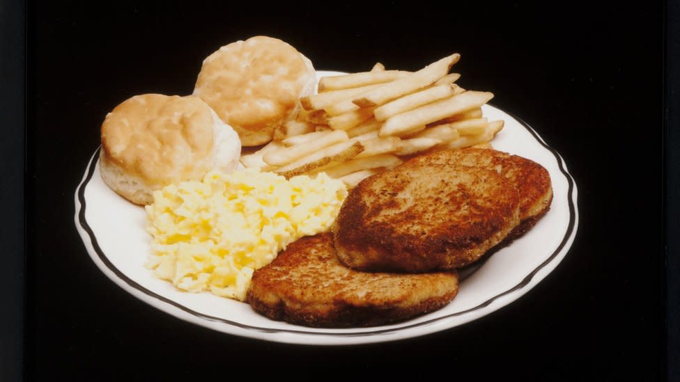 Papas fritas, dos panes dulces, huevos revueltos y tostadas.