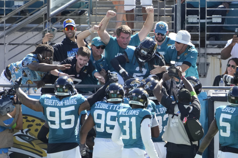 Jacksonville Jaguars safety Rayshawn Jenkins (2) celebrates his interception against the Indianapolis Colts with teammates and fans during the second half of an NFL football game, Sunday, Oct. 15, 2023, in Jacksonville, Fla. (AP Photo/John Raoux)