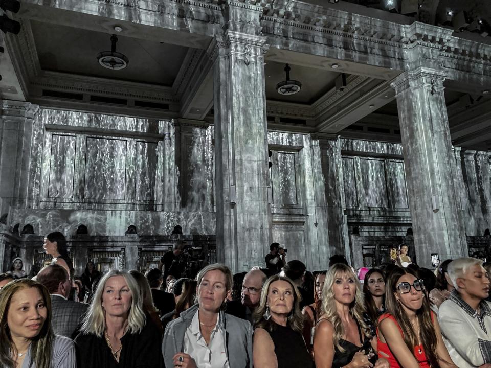 A theme of cascading waterfalls is projected on the marble walls surrounding the audience at the Proenza Schouler Spring Summer 2023 collection presentation during Fashion Week, Friday Sept. 9, 2022 in New York. (AP Photo/Jocelyn Noveck)