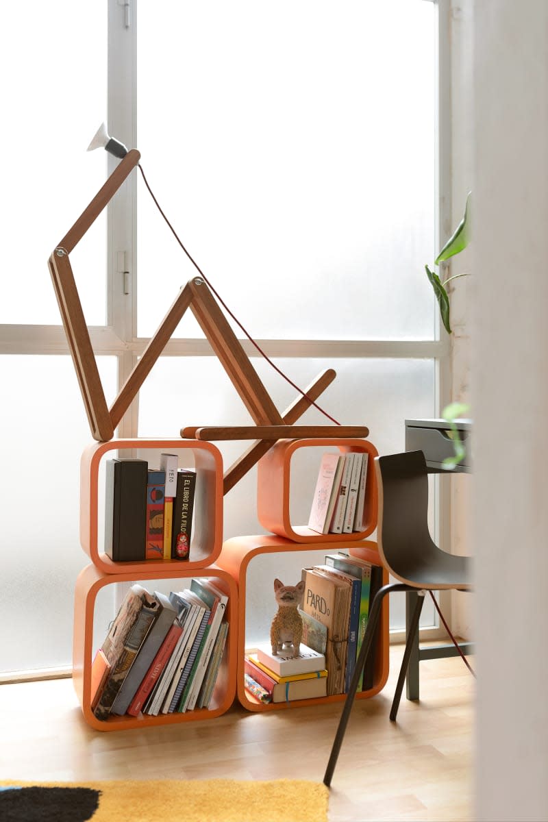 Orange cubes hold books in front of frosted windows.