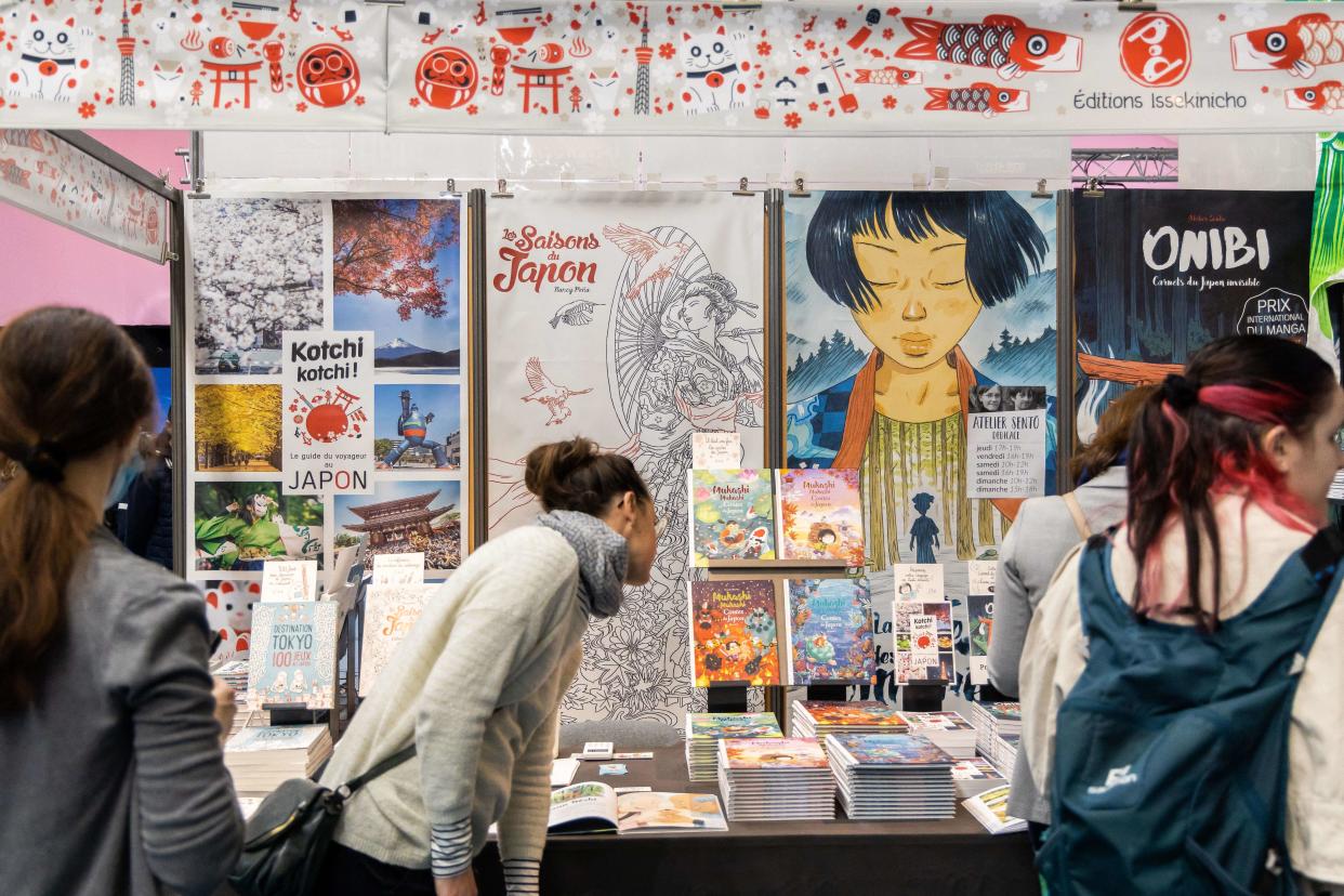 Visitors look at Editions Issekinicho comics book at Manga City section during the 49th Angouleme International Comics Festival (Festival International de la Bande Dessinee), in Angouleme, western France, on March 19, 2022. (Photo by YOHAN BONNET / AFP)