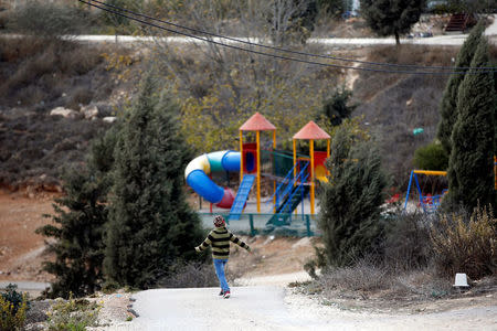 An Israeli boy walks near a playground in the Jewish settler outpost of Amona in the West Bank, November 22, 2016. REUTERS/Ronen Zvulun