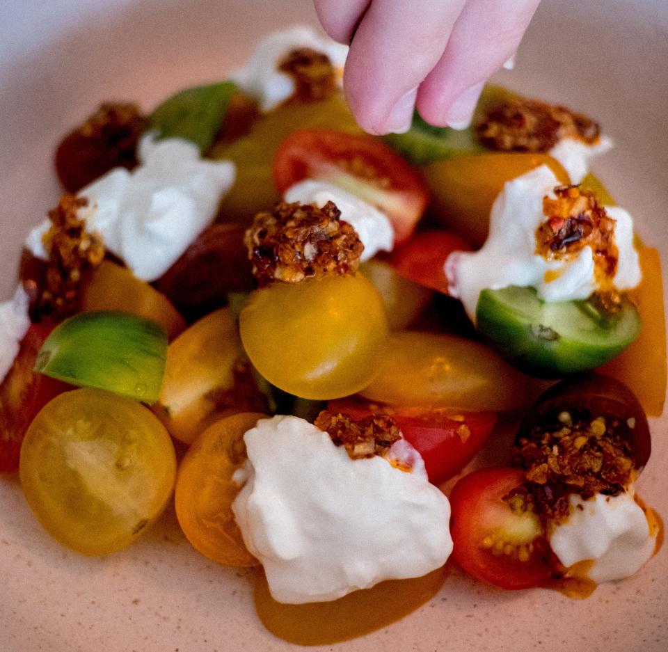 Baby heirloom tomatoes with burrata, chili crisp and extra virgin olive oil made by Michelle Ciance.