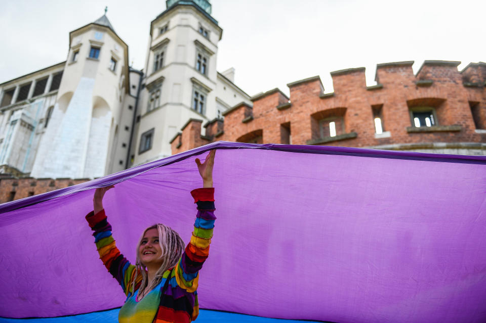 A woman holds a huge rainbow flag during the Pride Parade in Krakow.&nbsp;