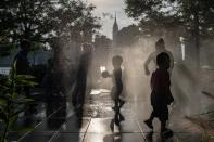 Children cool off in a fountain while enjoying a warm and humid day at Gantry Plaza State Park following the outbreak of the coronavirus disease (COVID-19), in Long Island City, New York