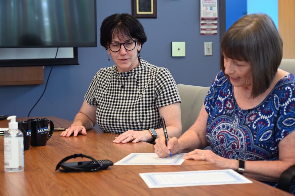 Dr. Amy Adams, executive vice president of planning, advancement and student engagement, looks on as Debbie Stark signs the agreement to create the new scholarship fund.