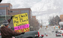 FILE PHOTO: FILE PHOTO: U.S. Internal Revenue Services (IRS) employee holds signs in front of the Federal building at a rally against the ongoing U.S. federal government shutdown, in Ogden, Utah, U.S., January 10, 2019. REUTERS/George Frey/File Photo/File Photo