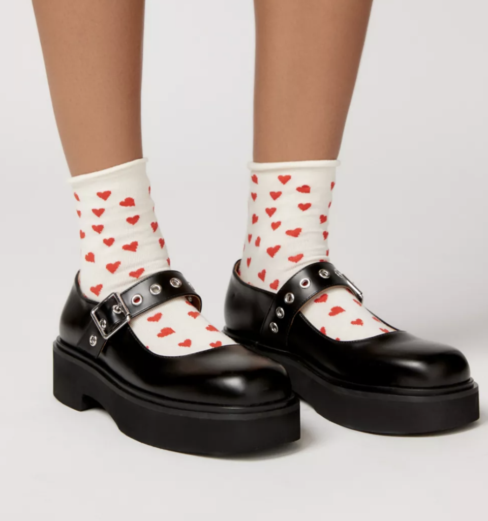 model wearing black mary janes with heart socks