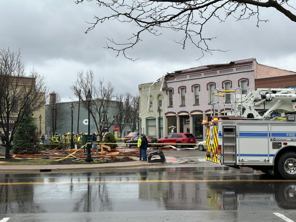 Firefighters, police and other village officials examine building damage in downtown Dundee caused by a severe thunderstorm that moved through the area Saturday morning, April 1, 2023.