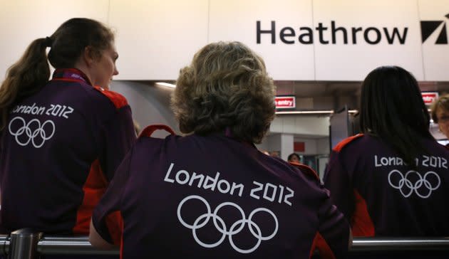 LONDON, ENGLAND - JULY 16: Olympic volunteers wait to greet arriving teams at Heathrow Airport on July 16, 2012 in London, England. Athletes, coaches and Olympic officials are beginning to arrive in London ahead of the Olympics.