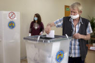 A man casts his vote in a snap parliamentary election, in Chisinau, Moldova, Sunday, July 11, 2021. Moldovan citizens vote in a key snap parliamentary election that could decide whether the former Soviet republic fully embraces pro-Western reform or prolongs a political impasse with strong Russian influence. (AP Photo/Aurel Obreja)