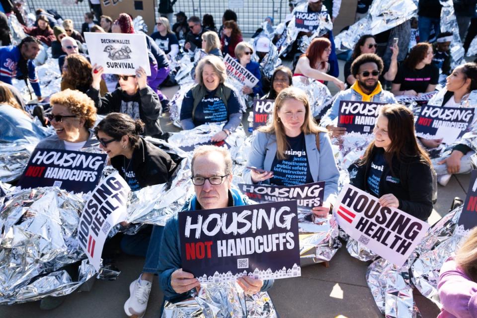 Homelessness activists hold signs and use reflective blankets during a protest outside the US Supreme Court in Washington, DC, April 22, 2024 (AFP via Getty Images)