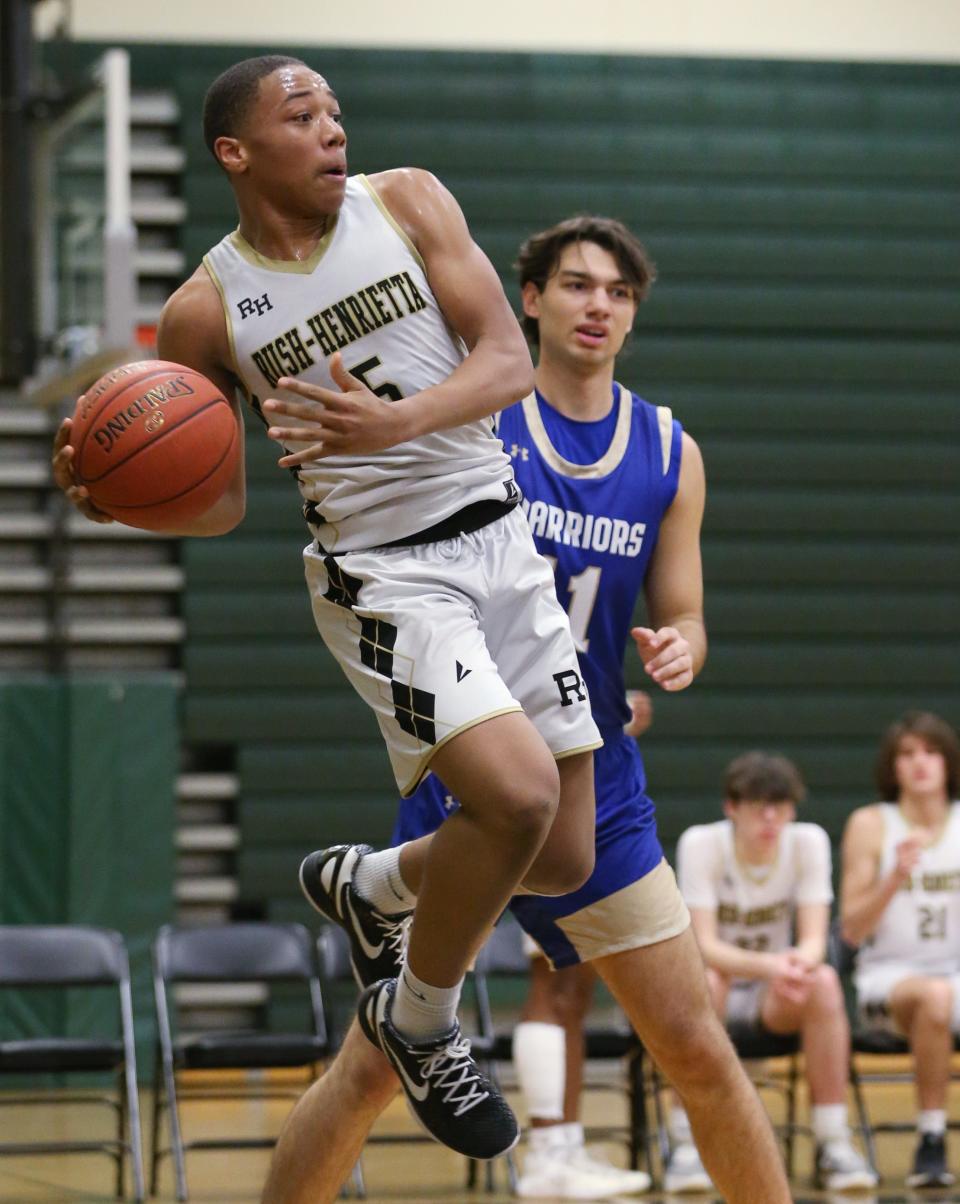 Rush-Henrietta's Avery Council tries to a save a loose ball along the baseline, throwing it back in as Schroeder's Joseph DiMarco looks on.