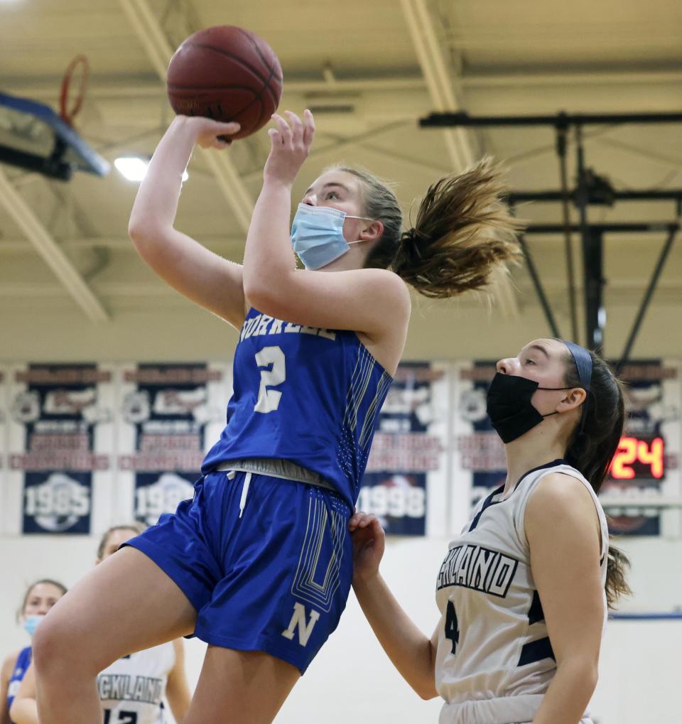 Norwell's Ellie Phillips scores a basket next to Rockland defender Charlie Kelleher during a game on Tuesday, Jan. 25, 2022.  